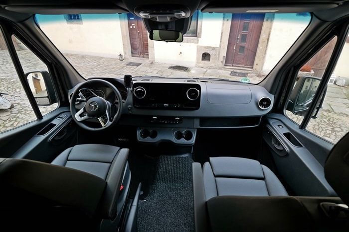 Der Innenraum eines Lieferwagens mit Lenkrad und Sitzen.