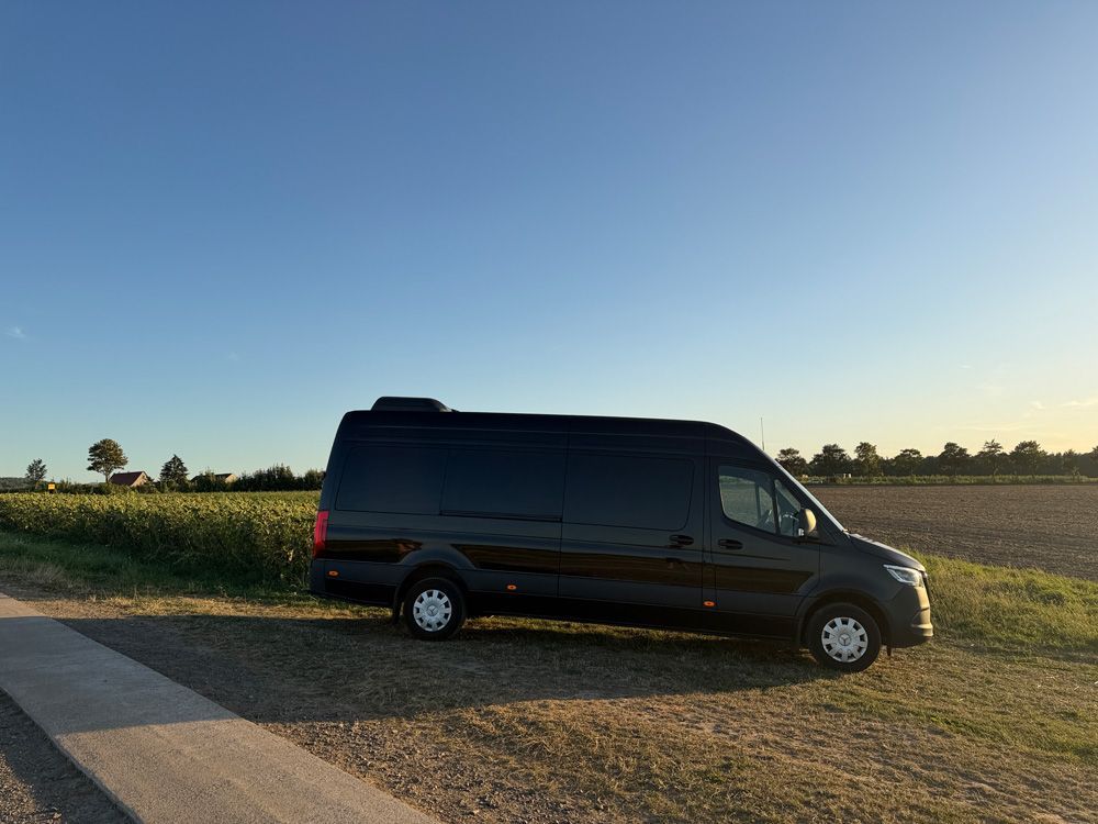 Ein schwarzer Lieferwagen steht vor einem Gebäude.