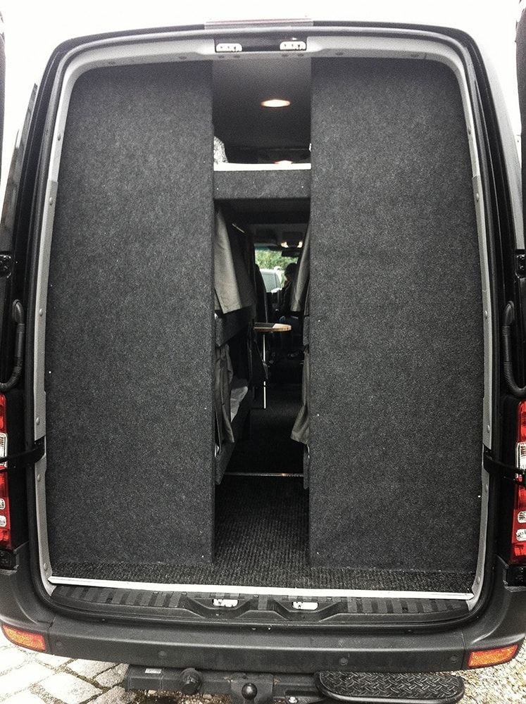 Die Rückseite eines schwarzen Lieferwagens mit offener Tür.