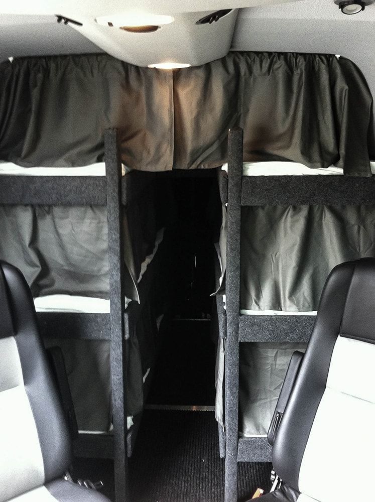 Das Innere eines Busses mit Etagenbetten und Vorhängen