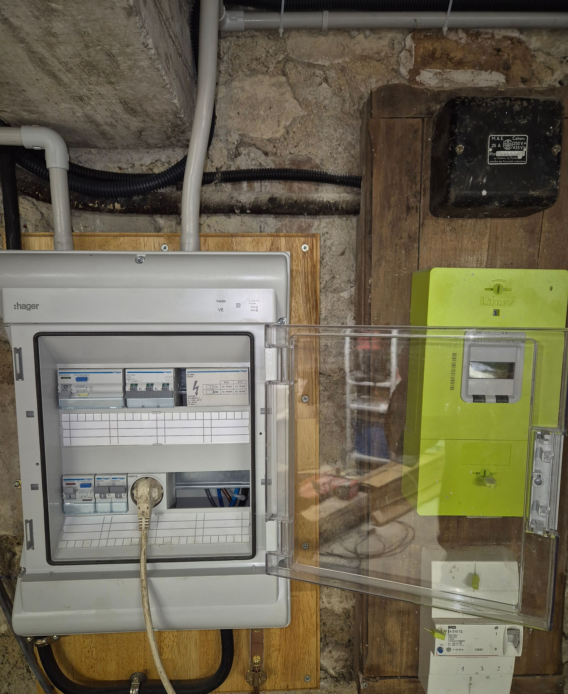 Tableau électrique mural avec disjoncteurs et compteur. Tons gris, verts et bruns.