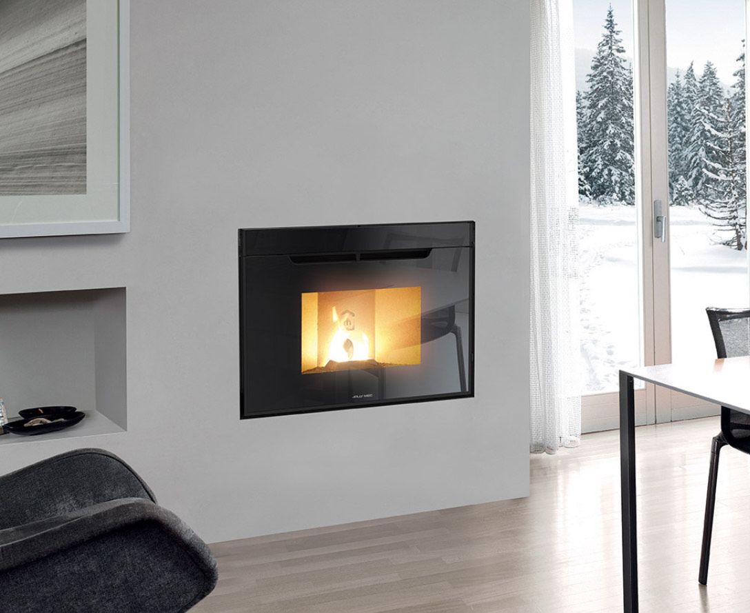 Cheminée noire moderne encastrée dans un mur blanc, feu qui crépite, paysage d'hiver par la fenêtre.