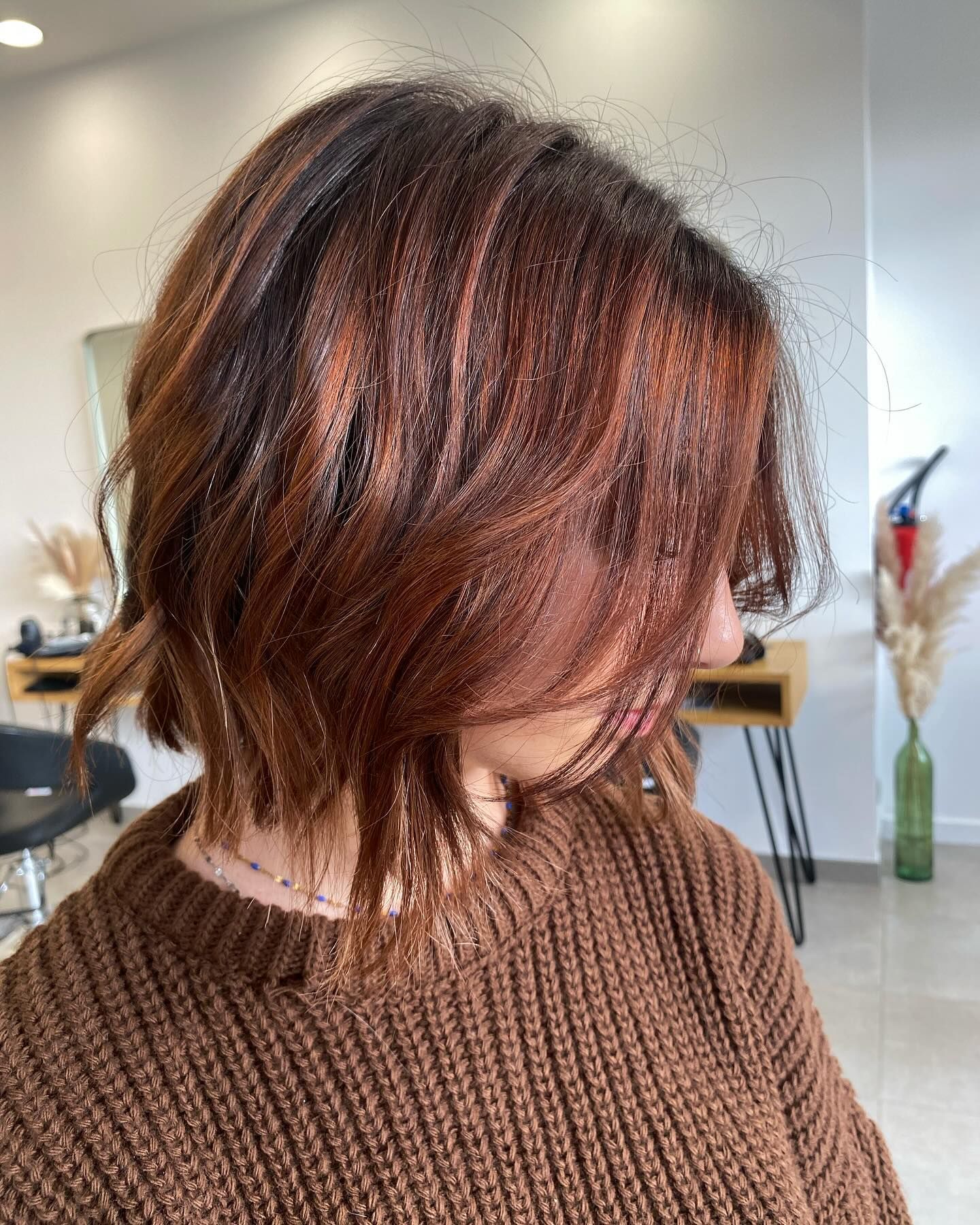 Femme aux cheveux auburn à l'intérieur, un salon de coiffure.