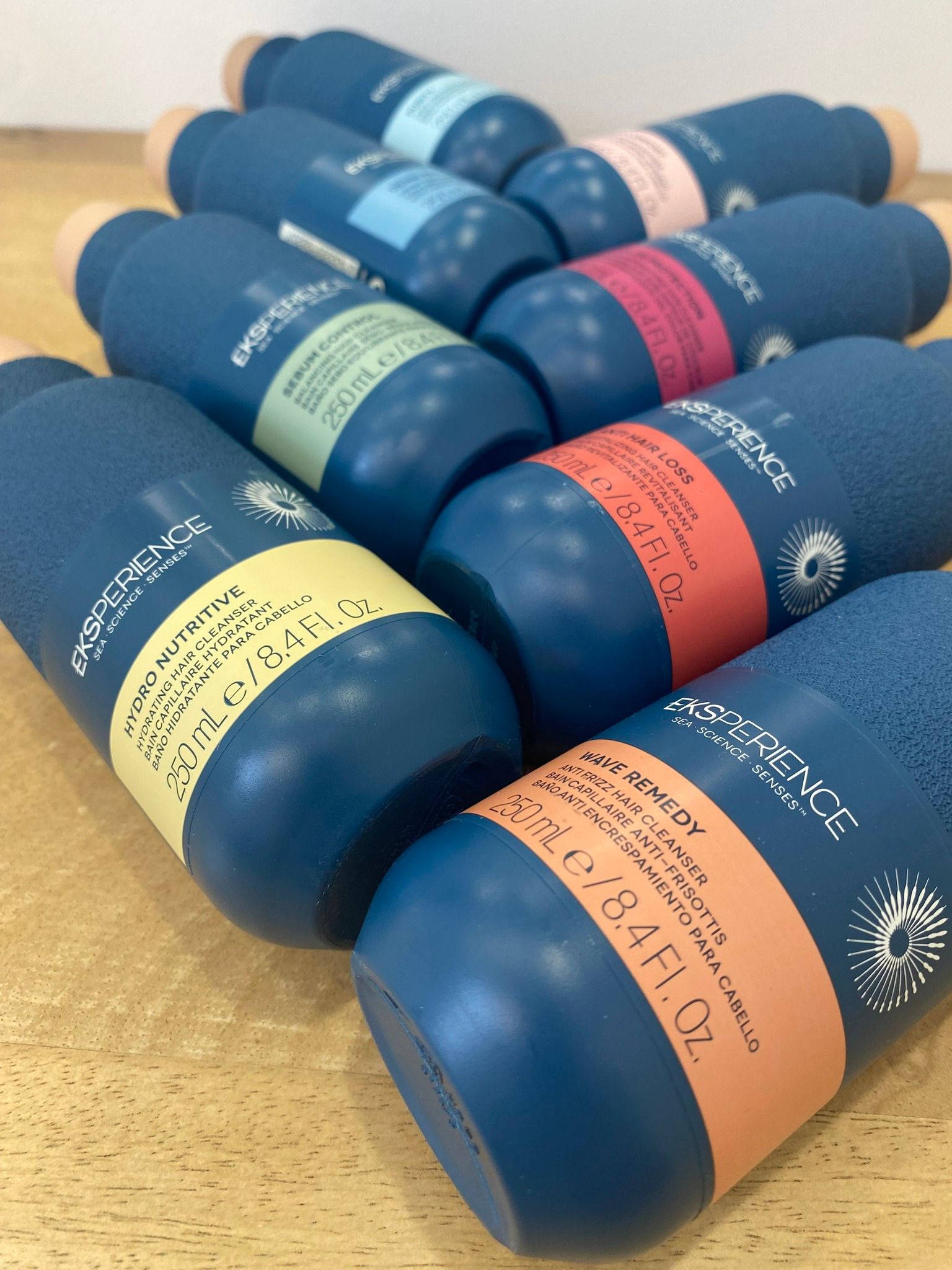 Bouteilles bleues aux étiquettes colorées posées sur une surface en bois.