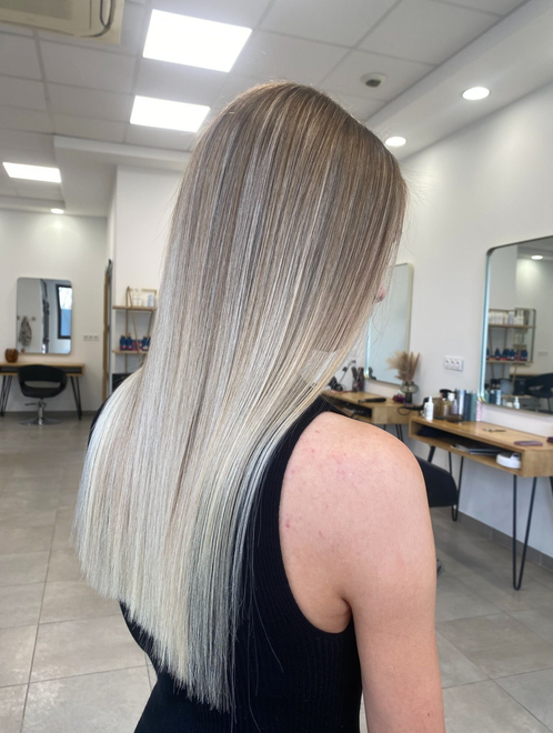 Femme avec des mèches blondes dans un salon de coiffure.