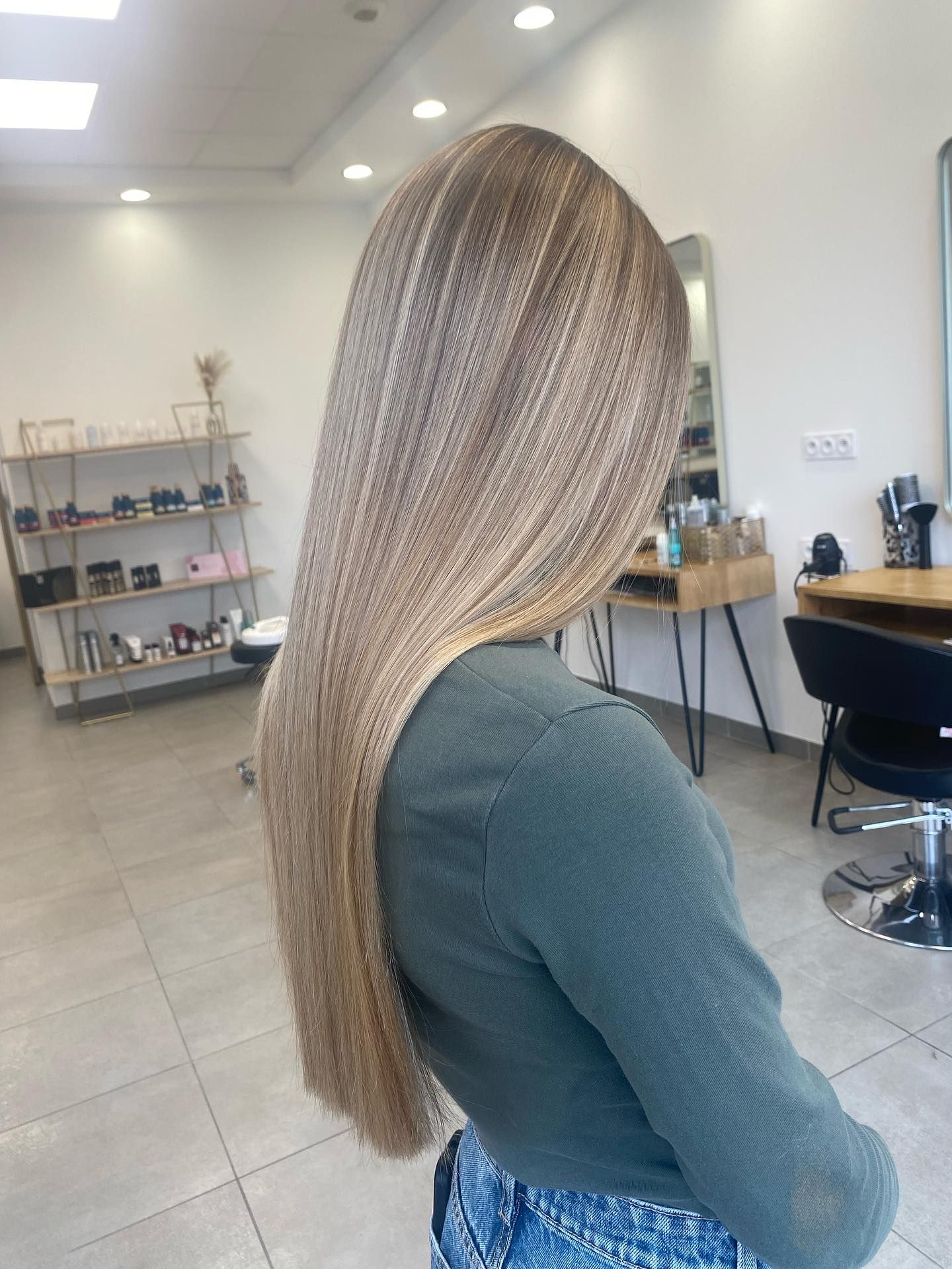 Femme avec des mèches blondes dans un salon de coiffure.