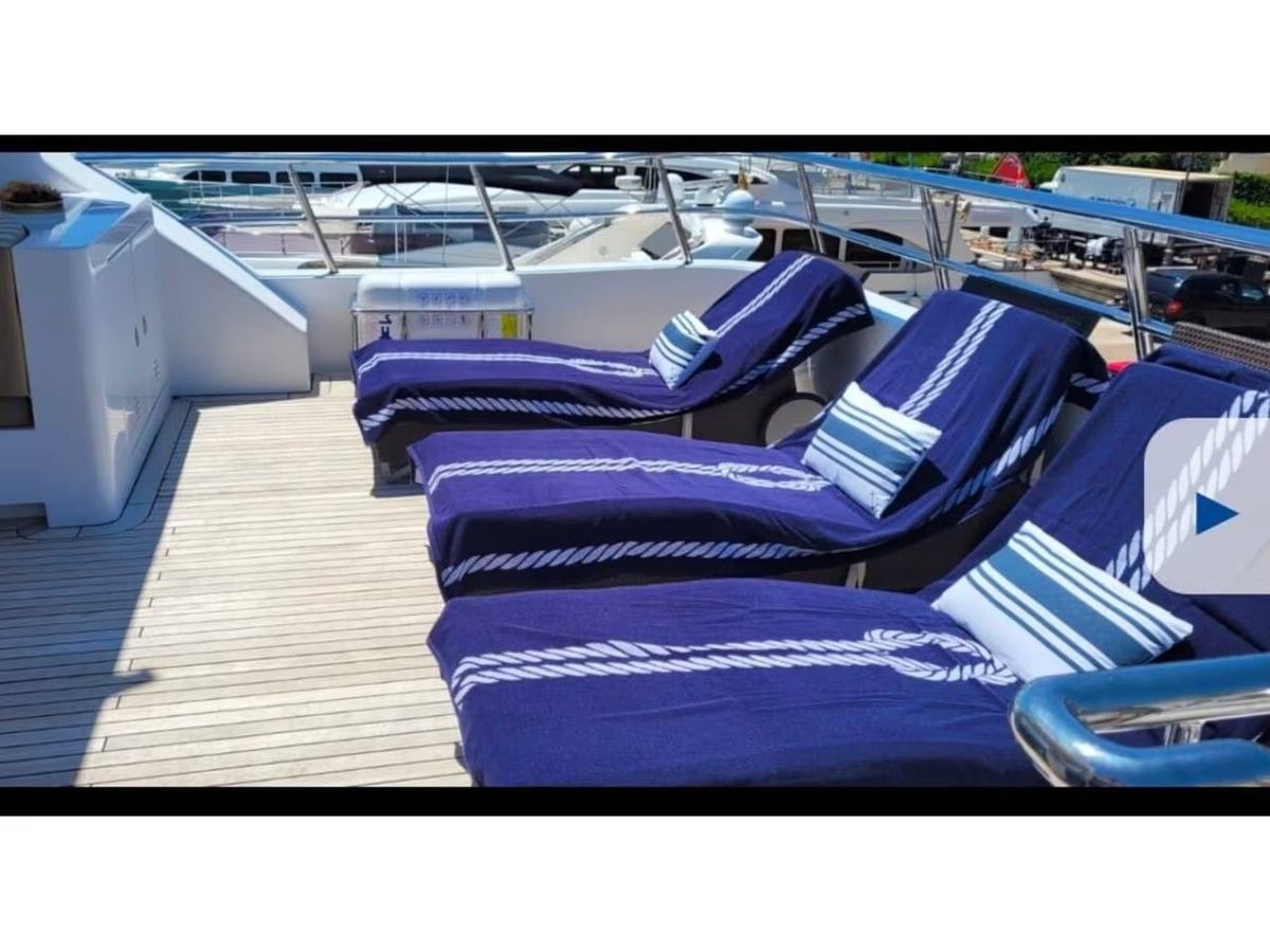 Una fila de sillones azules en la cubierta de un barco.