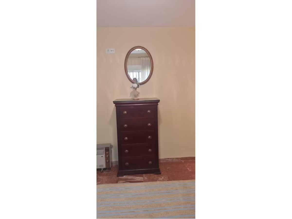 Un dormitorio con una cómoda y un espejo.