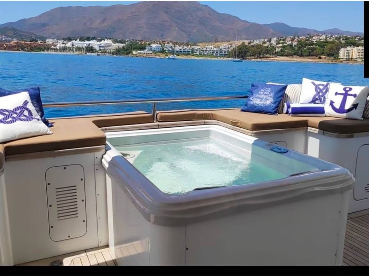 Un jacuzzi en un barco con montañas al fondo.