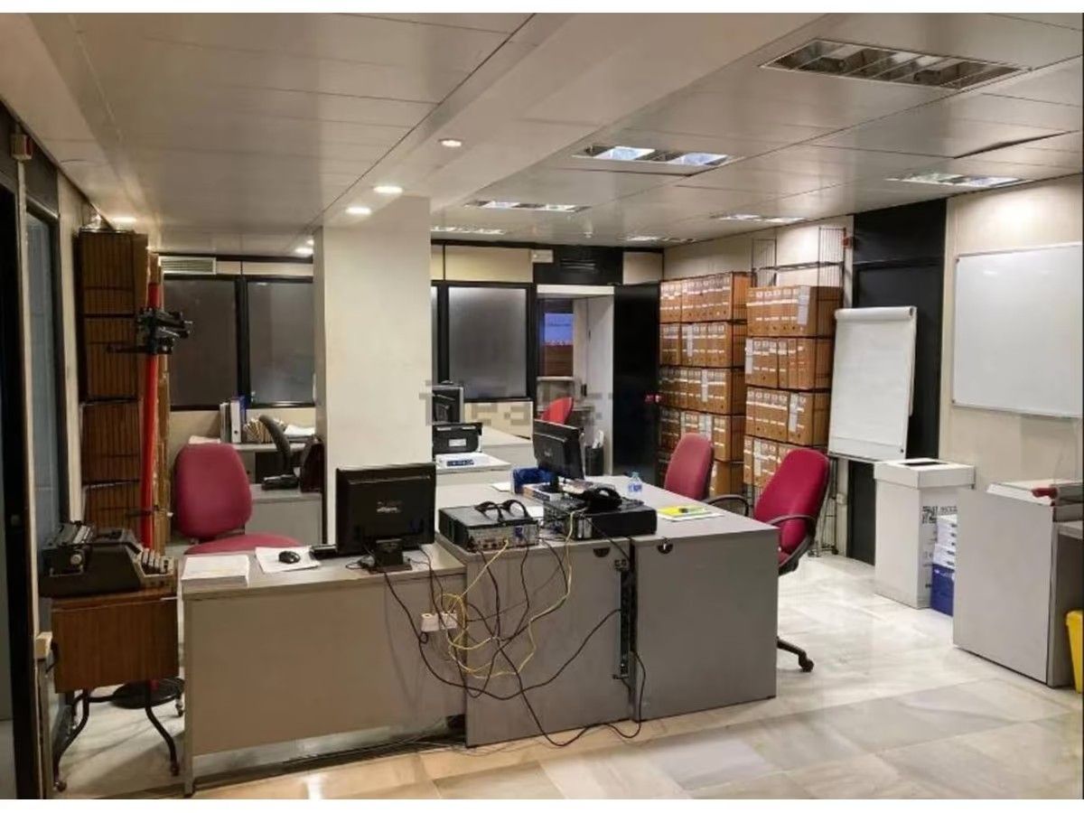 Una oficina grande con muchos escritorios y sillas.