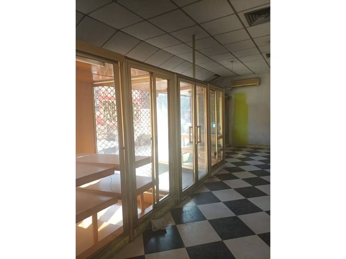 Una habitación con muchas ventanas y suelo cuadriculado.