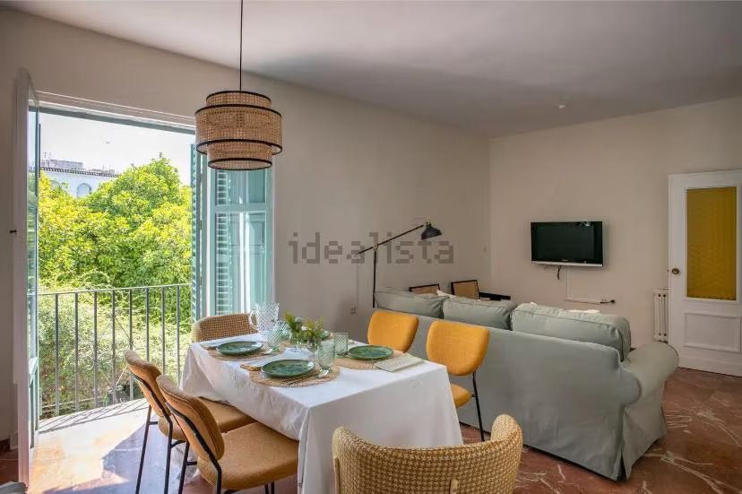 Una sala de estar con una mesa y sillas y un televisor de pantalla plana.