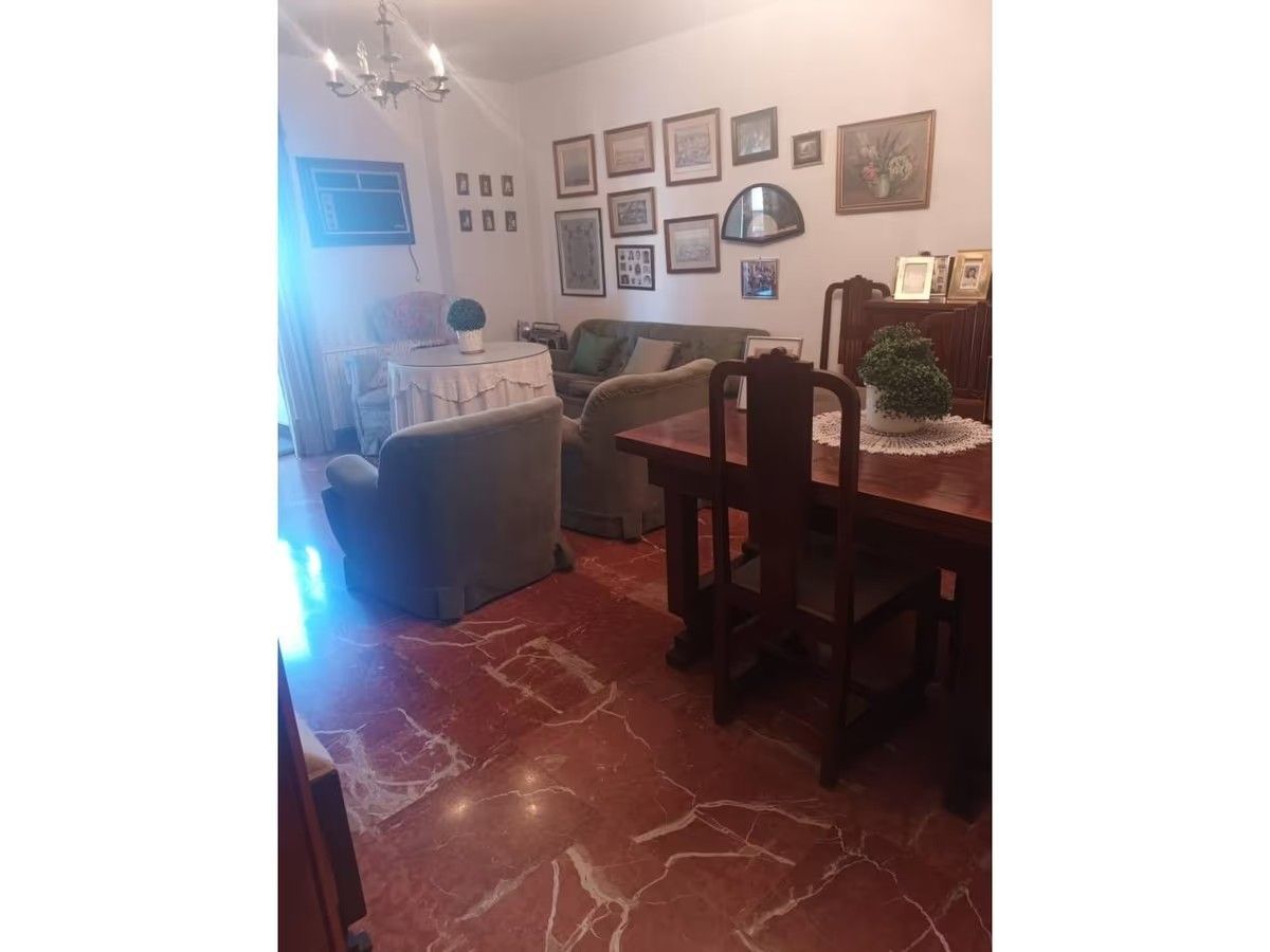 Una sala de estar con una mesa y sillas y un sofá.