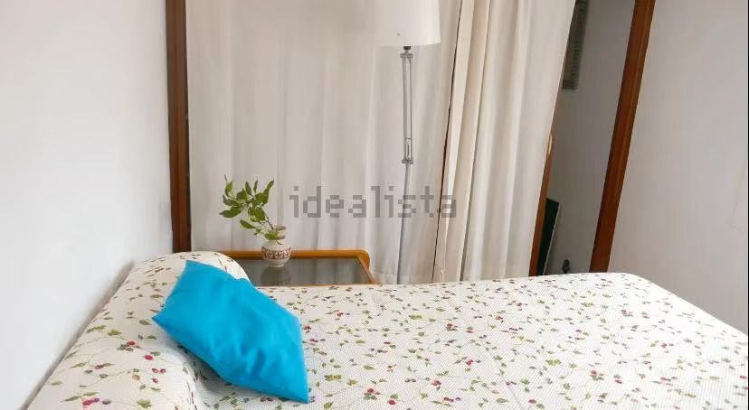 Una cama con una almohada azul encima en un dormitorio.