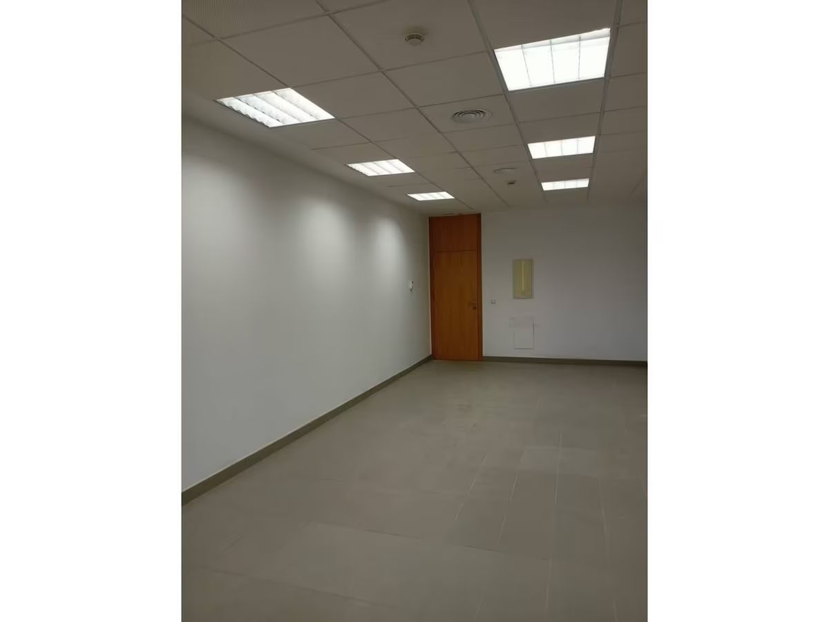 Una habitación vacía con una puerta y luces de techo.