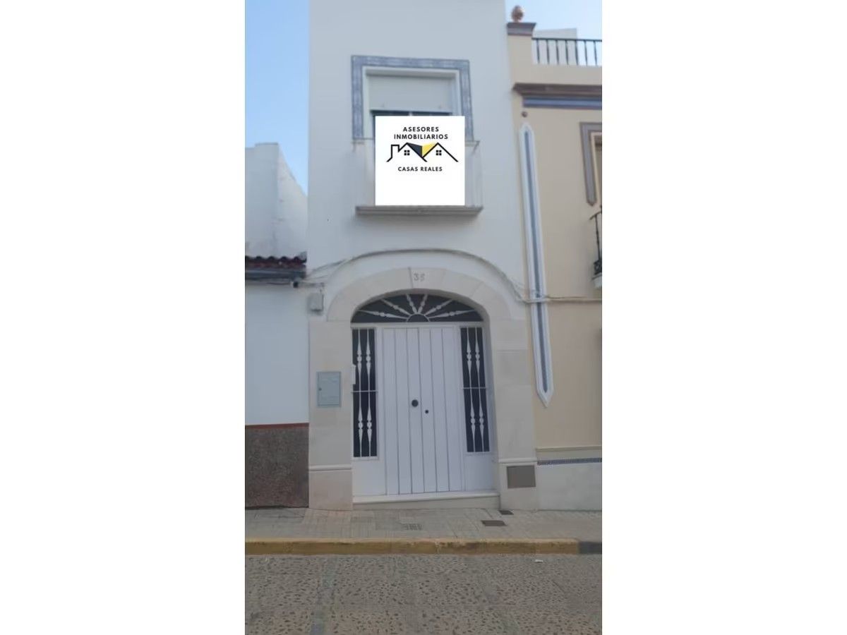 Un edificio blanco con un balcón y un cartel que dice 'alquiler'.