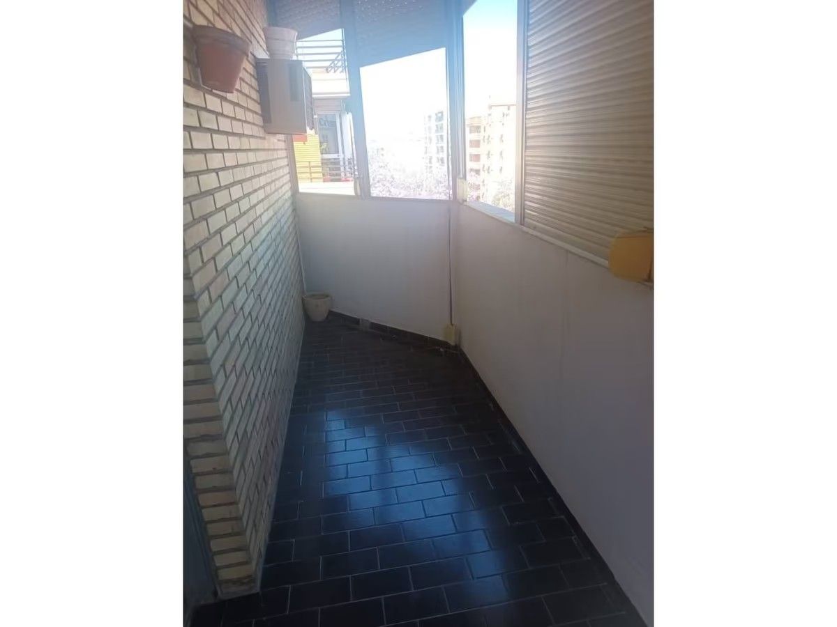 Un pasillo largo con una pared de ladrillos y una ventana.