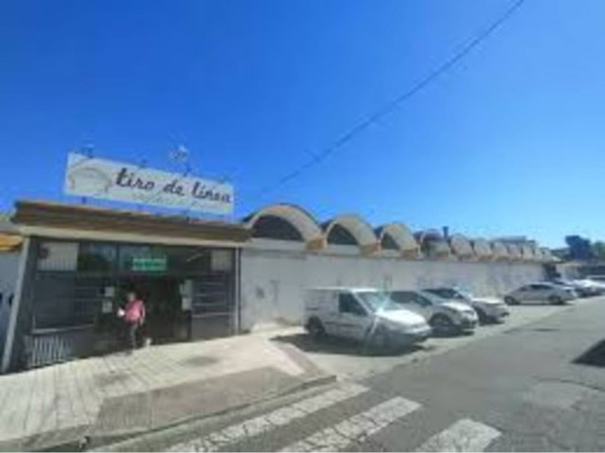 Una fila de coches están aparcados delante de un edificio.