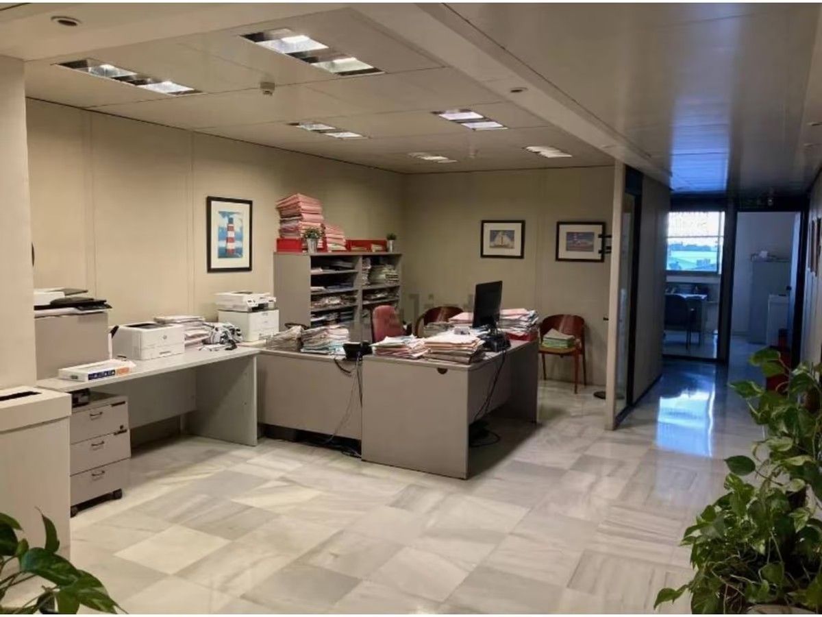 Una oficina grande con muchos escritorios y sillas.