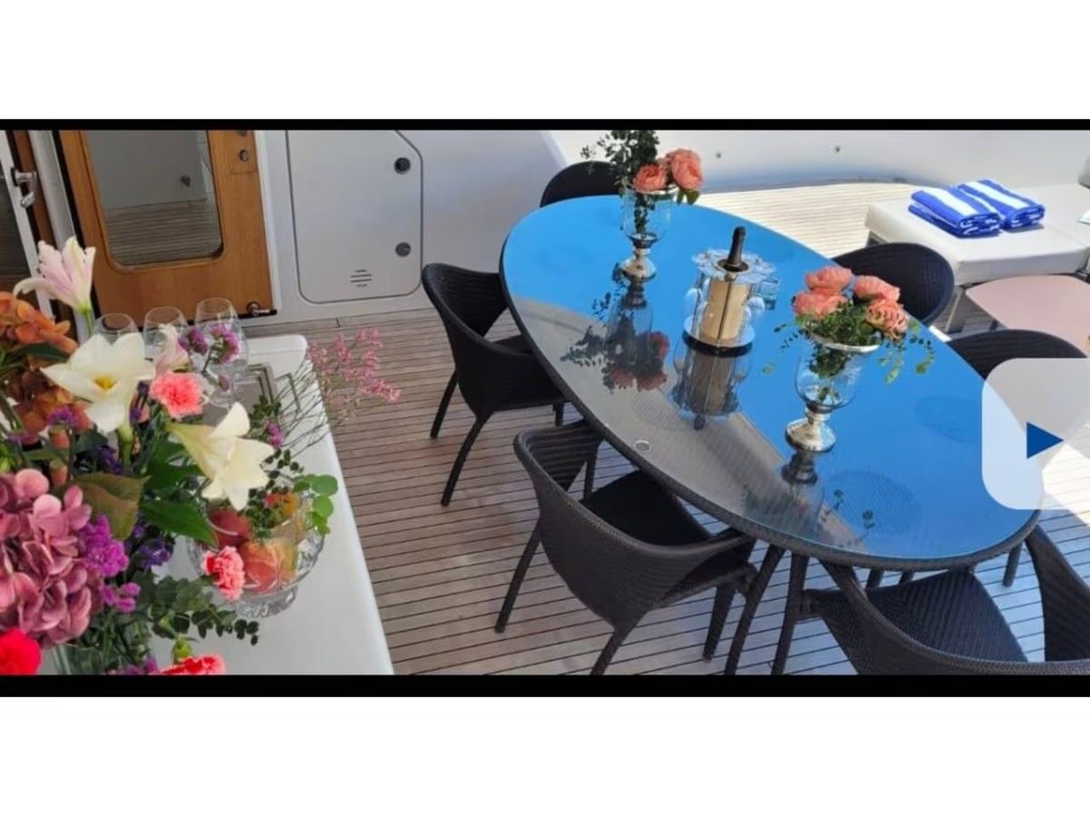 Una mesa con flores y una botella de vino encima.