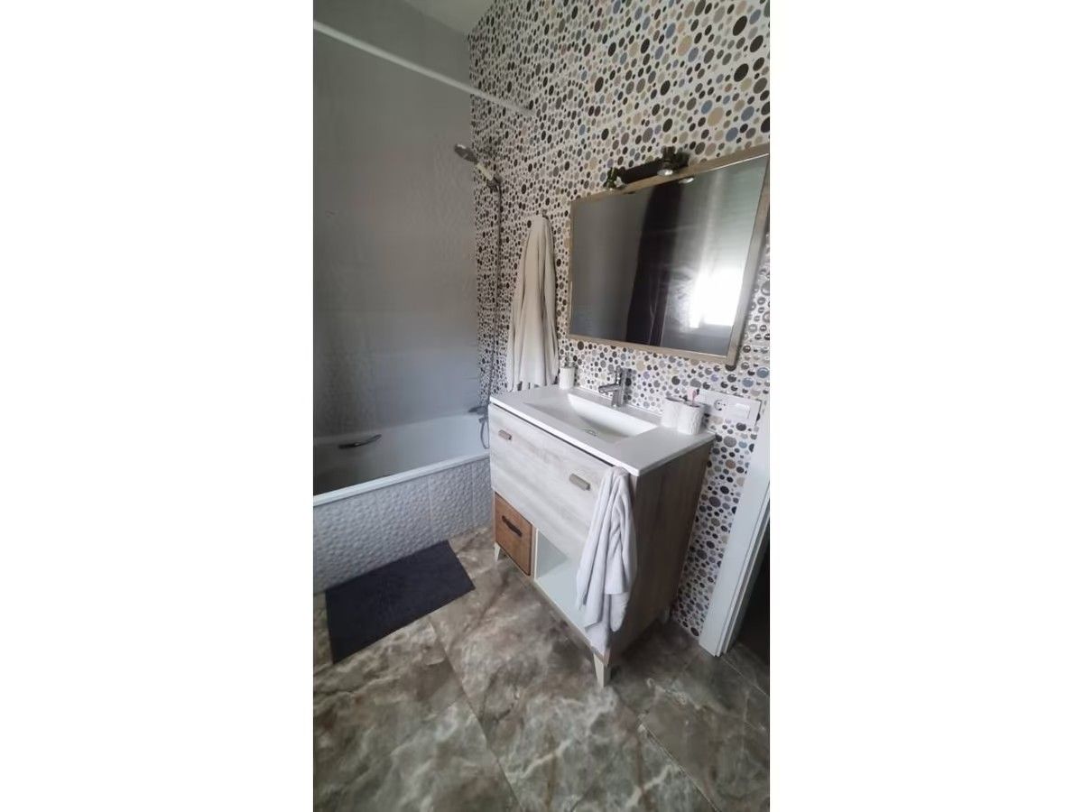 Un baño con lavabo, espejo y bañera.