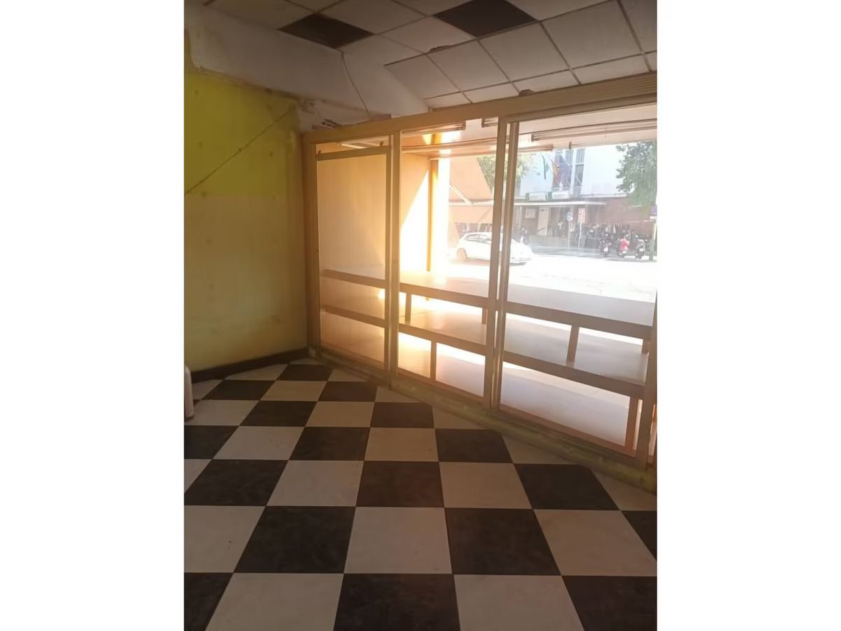 Una habitación con suelo cuadriculado y una gran ventana.