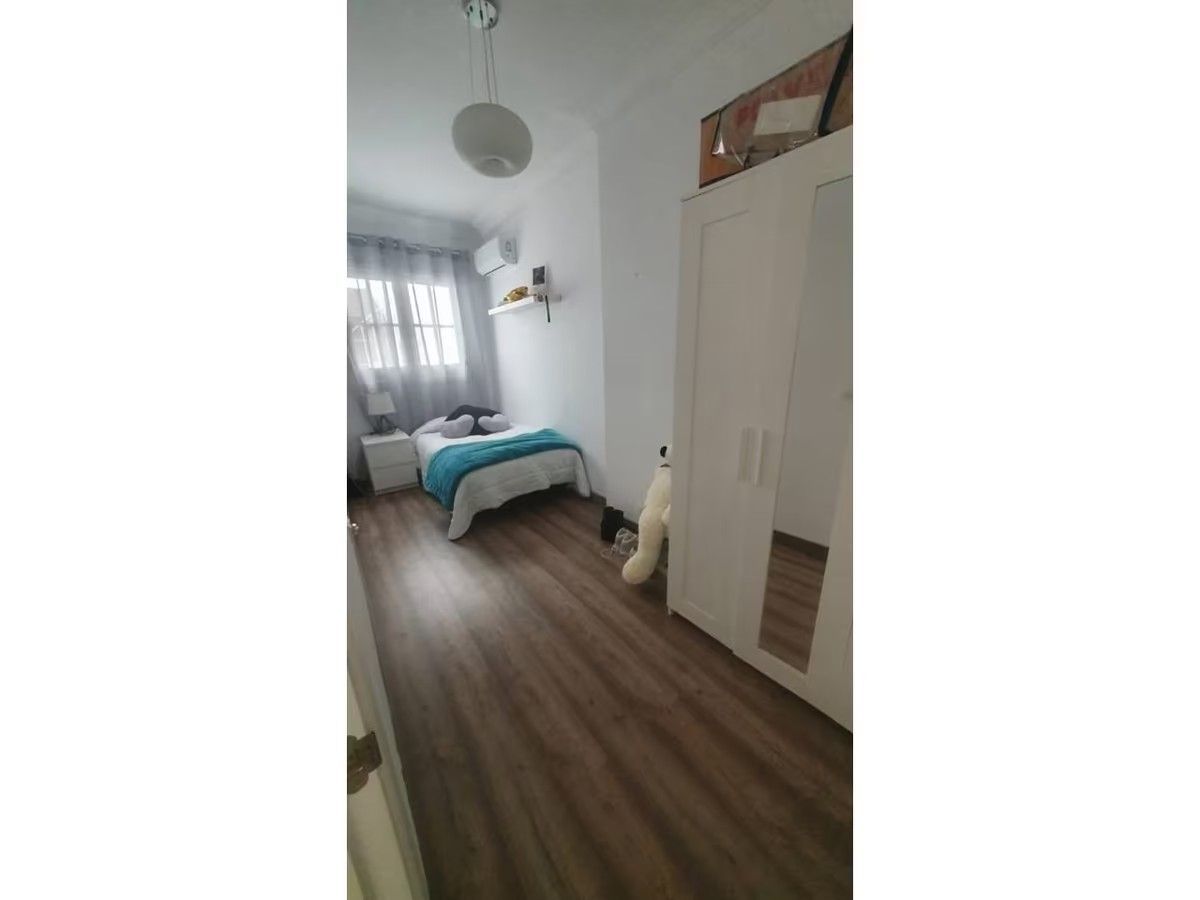 Un dormitorio con cama, armario y espejo.