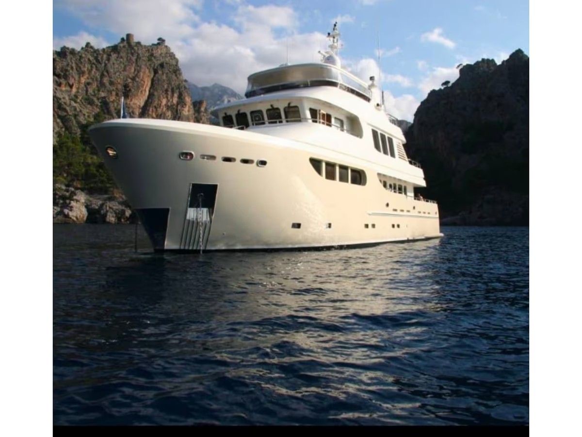 Un gran yate blanco flota sobre un cuerpo de agua.