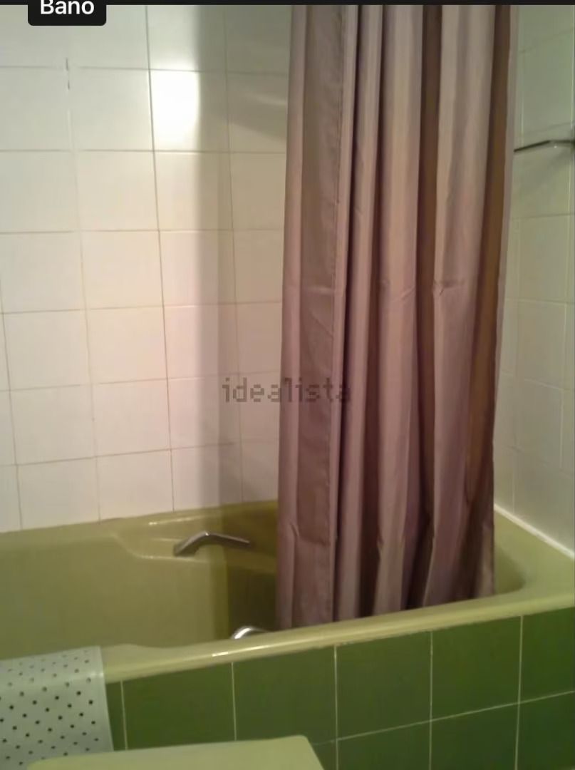 Una bañera con cortina de ducha y un cartel que dice bano