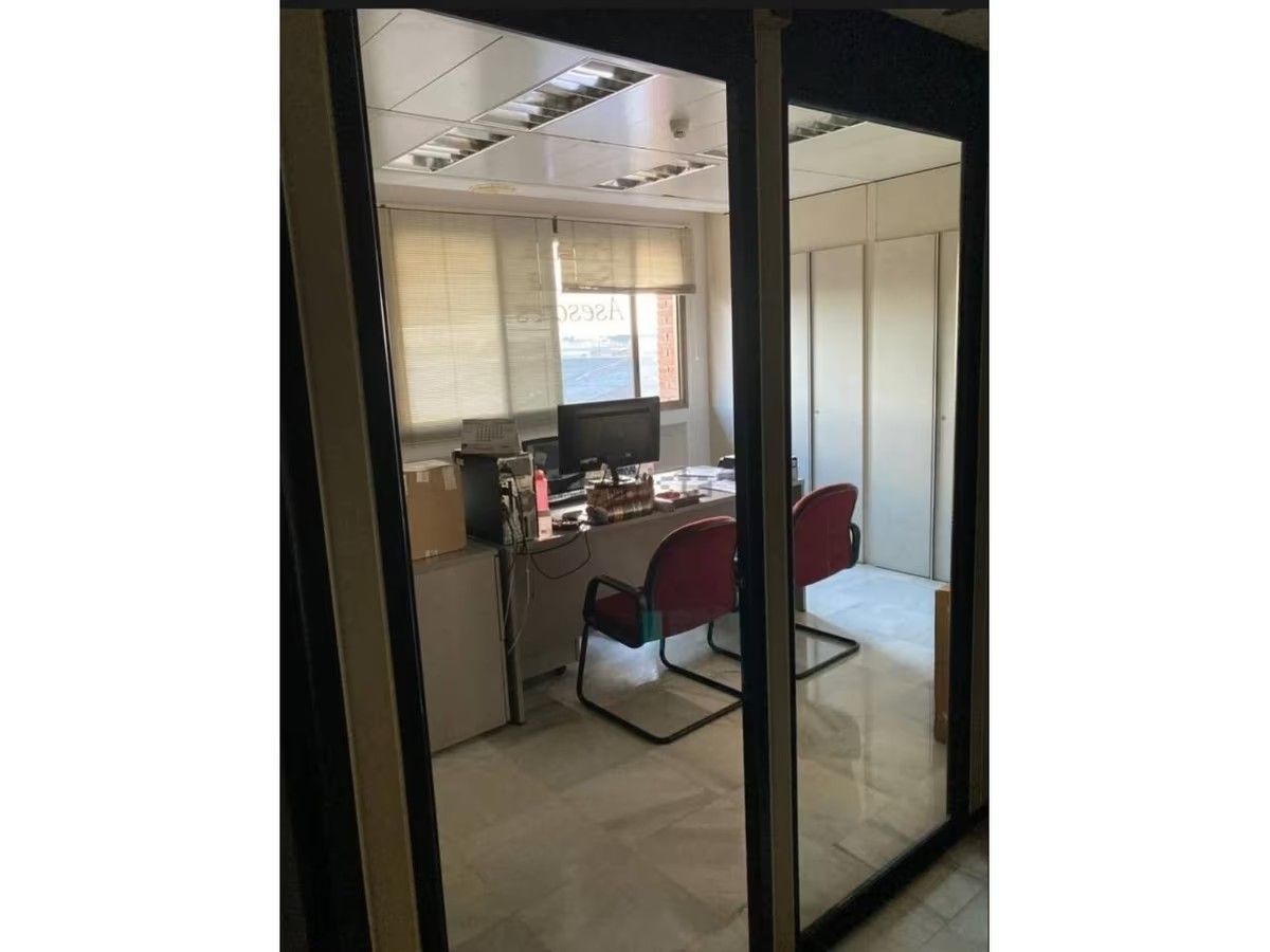 Una habitación con un escritorio y sillas.