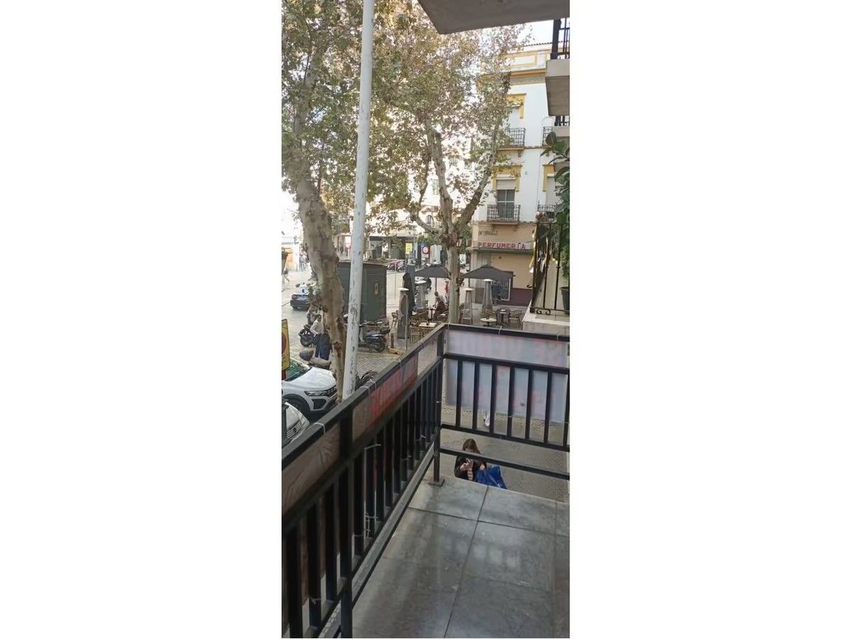 Un balcón con barandilla y vista a una calle de la ciudad.