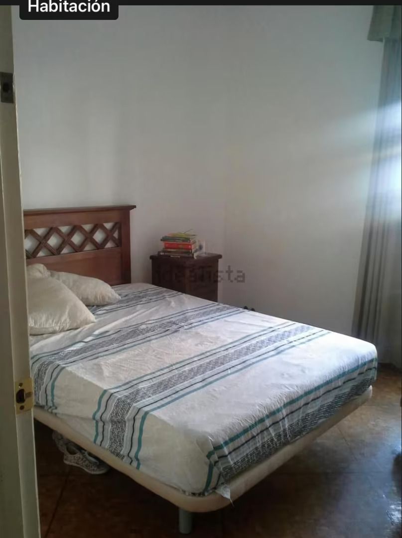 Un dormitorio con una cama y una mesita de noche.