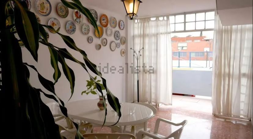 Una habitación con una mesa y sillas y platos en la pared.