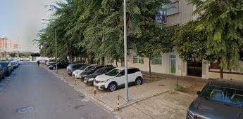 Una fila de coches están estacionados al costado de una calle.