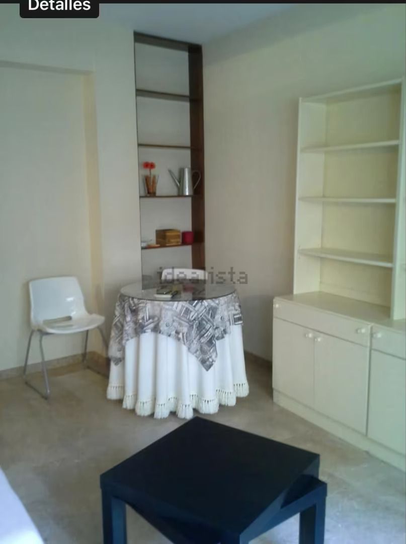 Una sala de estar con una mesa con un mantel blanco.