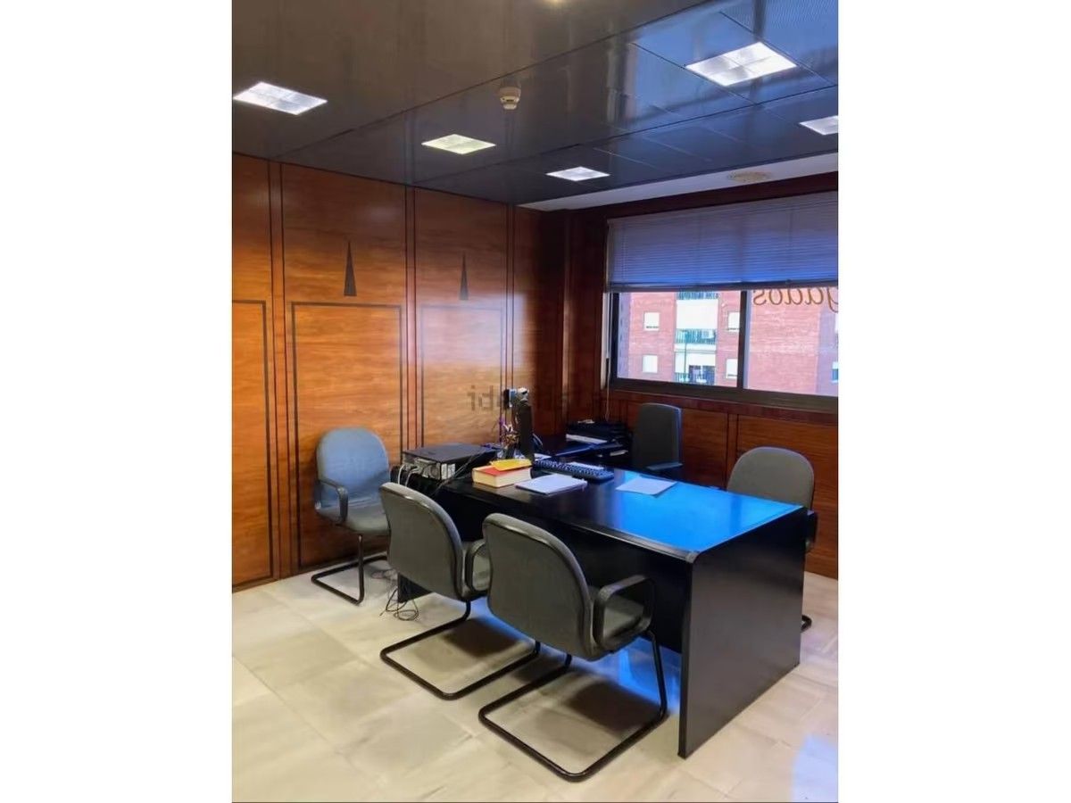 Una habitación con un escritorio y sillas.