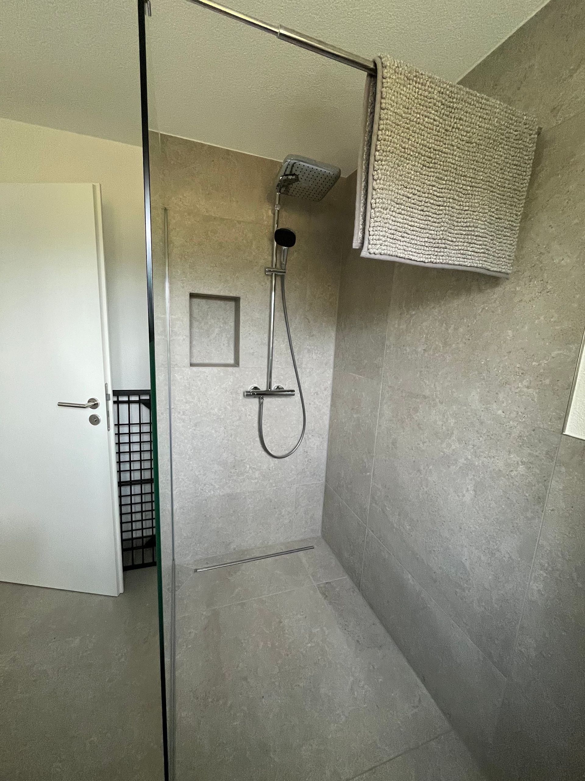 Waschküche mit Waschmaschine, Trockner, Waschbecken, Badewanne und Handtuchhalter.