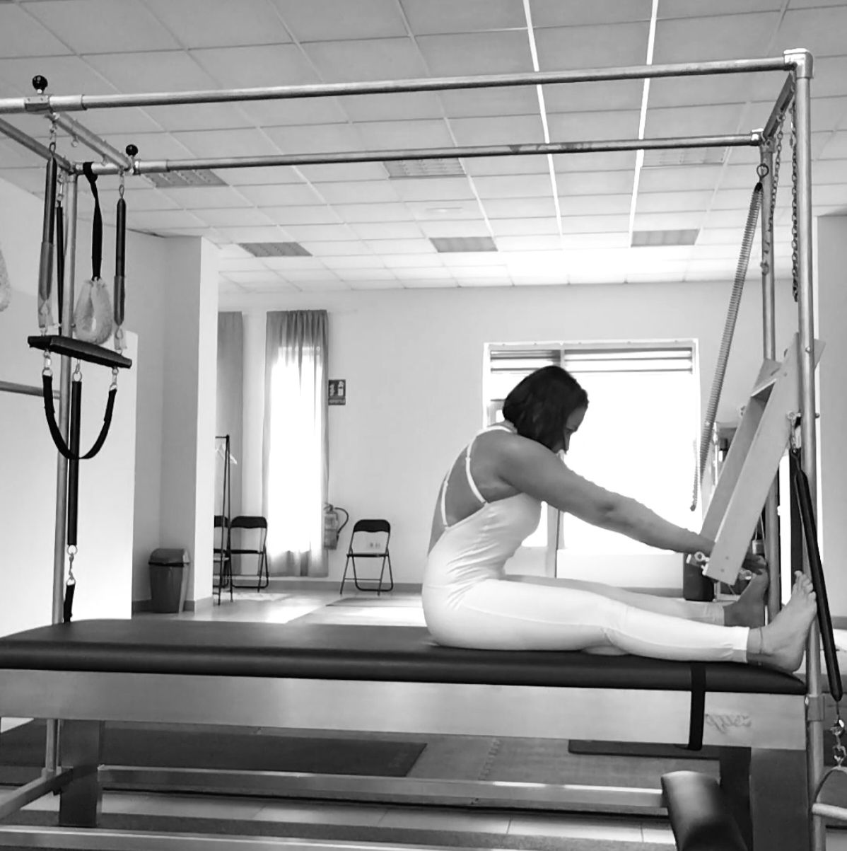 Una máquina de pilates cuelga del techo en un gimnasio.