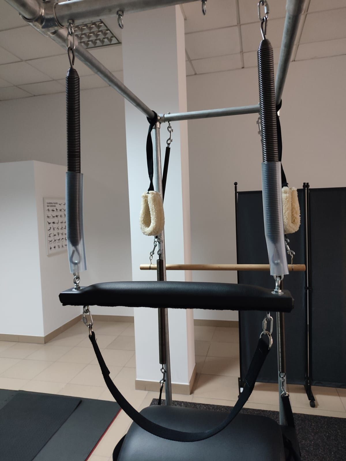 Una máquina de pilates cuelga del techo en un gimnasio.