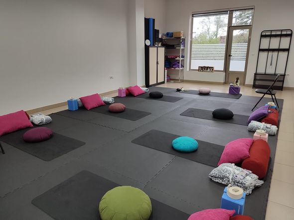 Una habitación llena de colchonetas de yoga y almohadas.