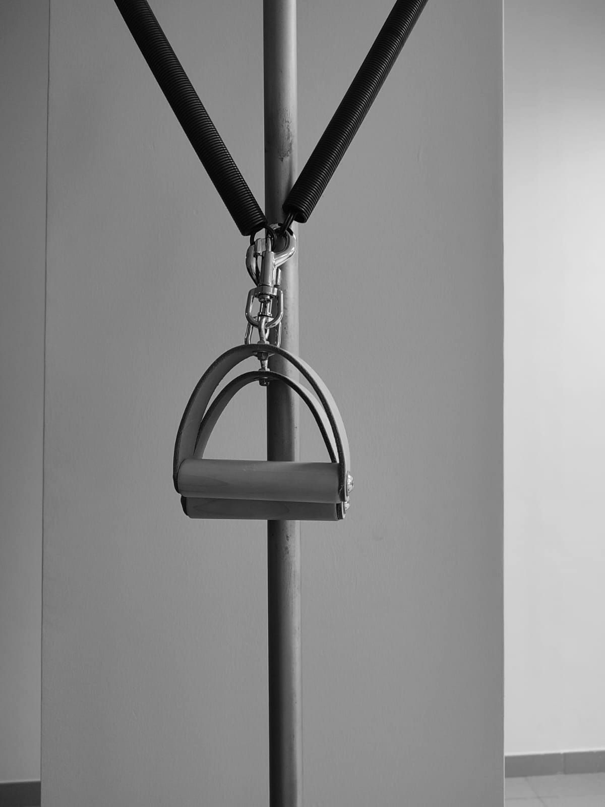 Una fotografía en blanco y negro de un poste con un mango adjunto.