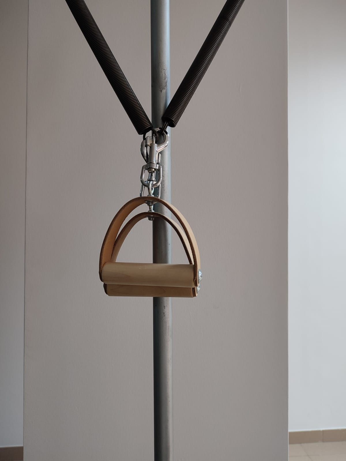 Un mango de madera cuelga de un poste de metal.