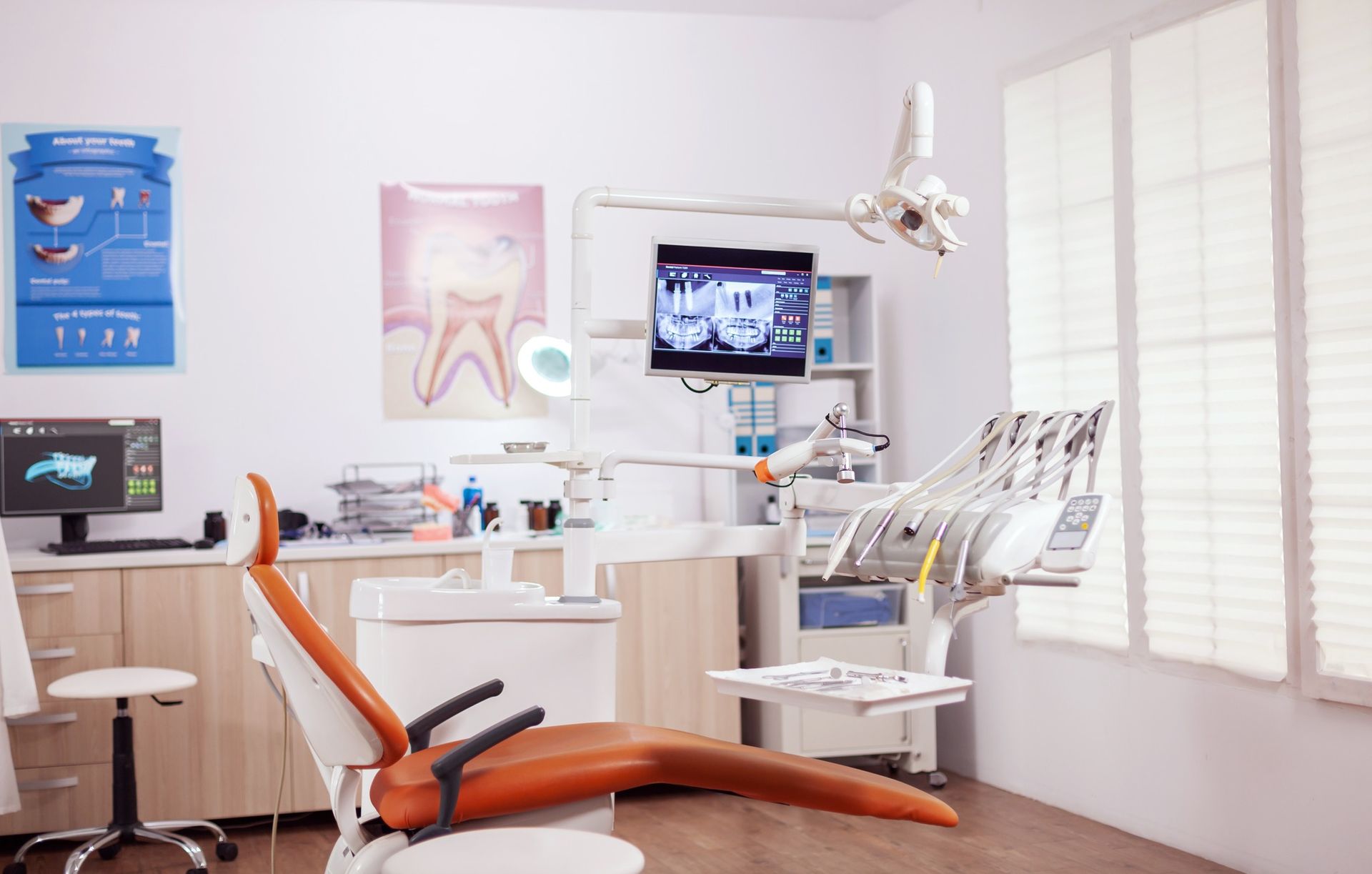 Un consultorio dental con un sillón dental y una computadora.