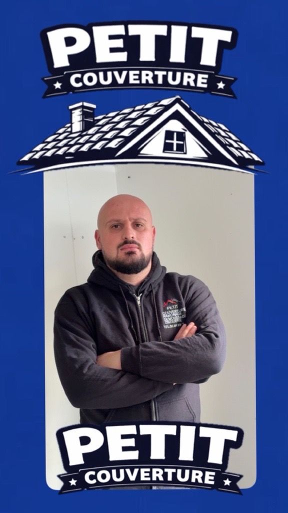 Un couvreur, portant un casque jaune et une salopette bleue, pose des bardeaux sur un toit de tuiles rouges.