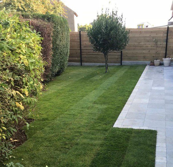 Gazon avec une terrasse et une clôture