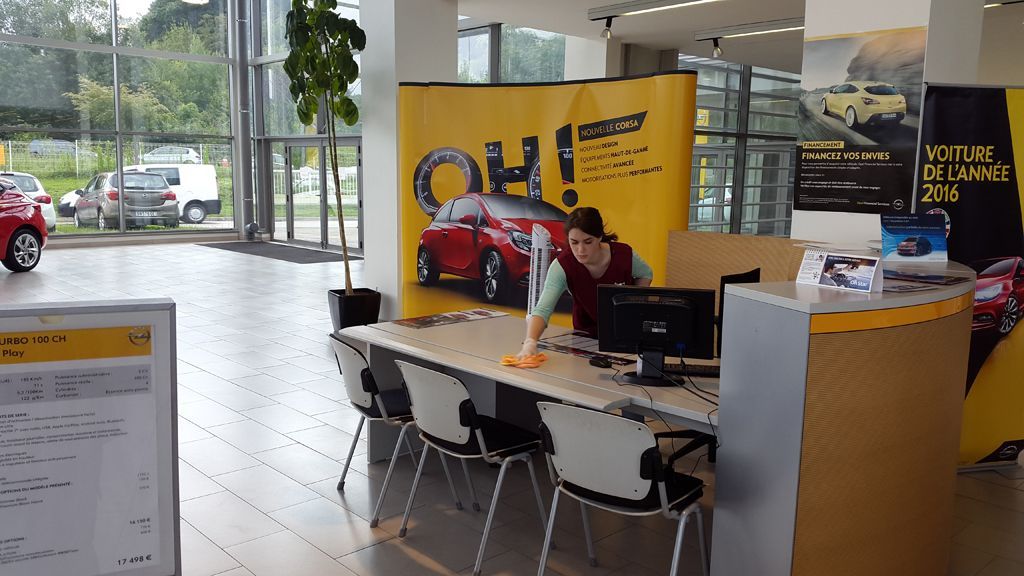 Une employée nettoie un bureau.