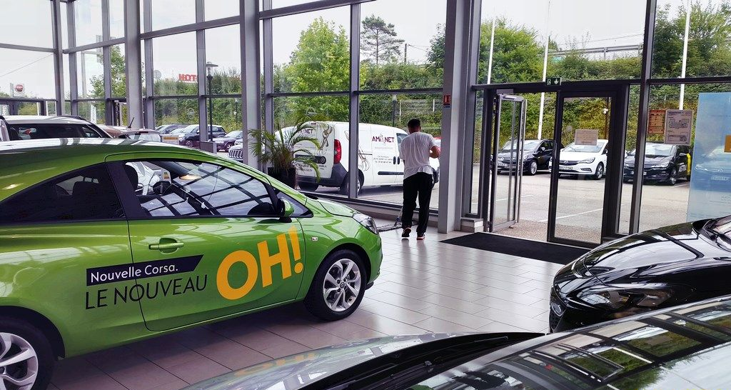 L'agent Ami Net nettoie le sol d'une concession automobile.