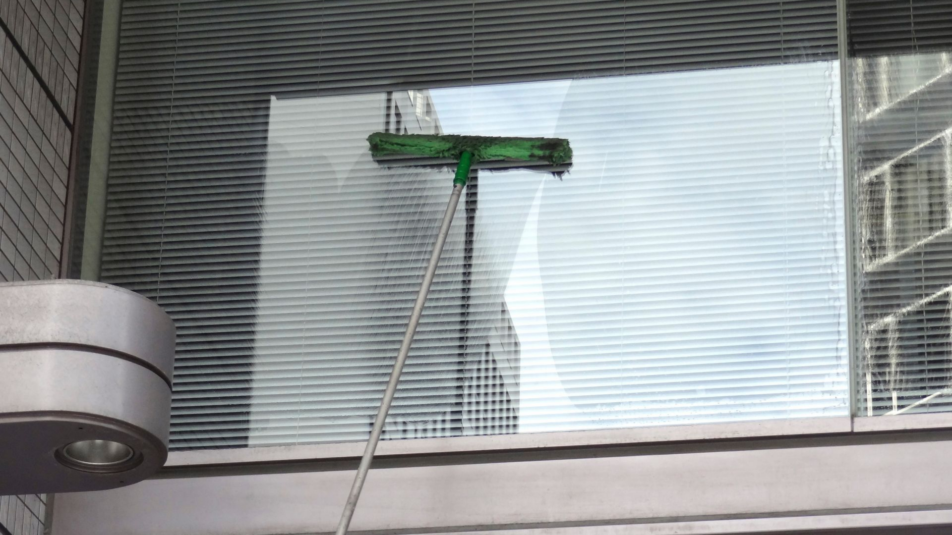 Nettoyage d'une vitre située en hauteur.