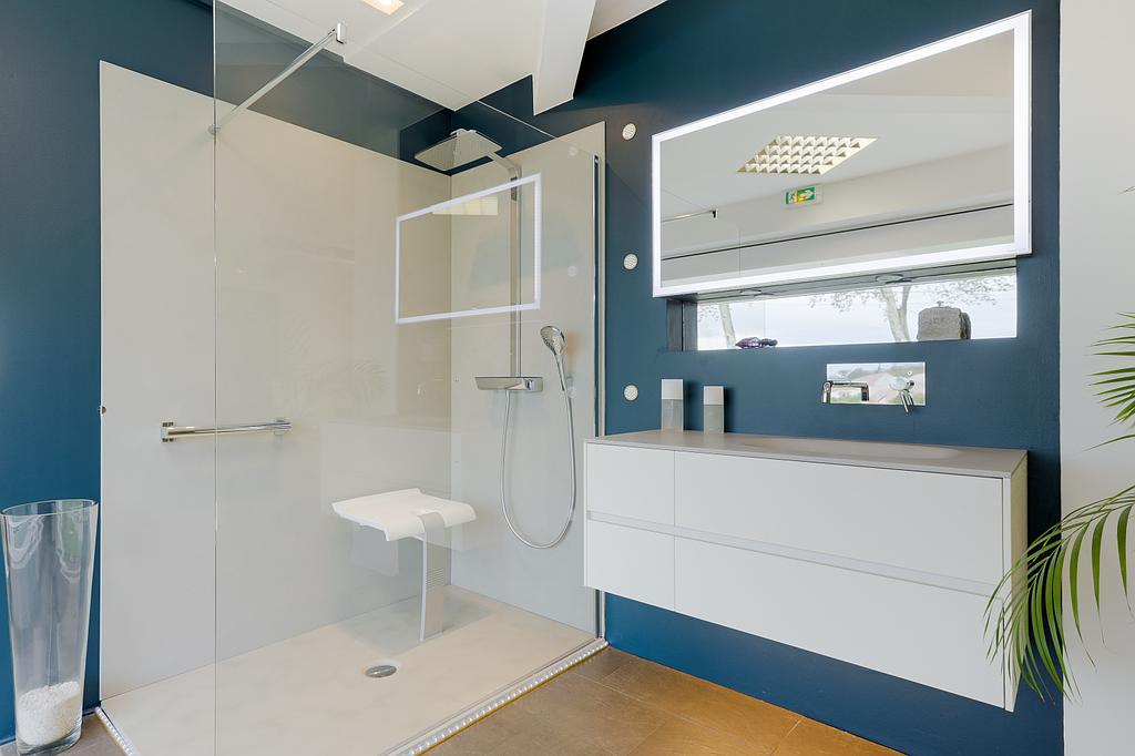 Salle de bains bleue marine avec une douche à l'italienne