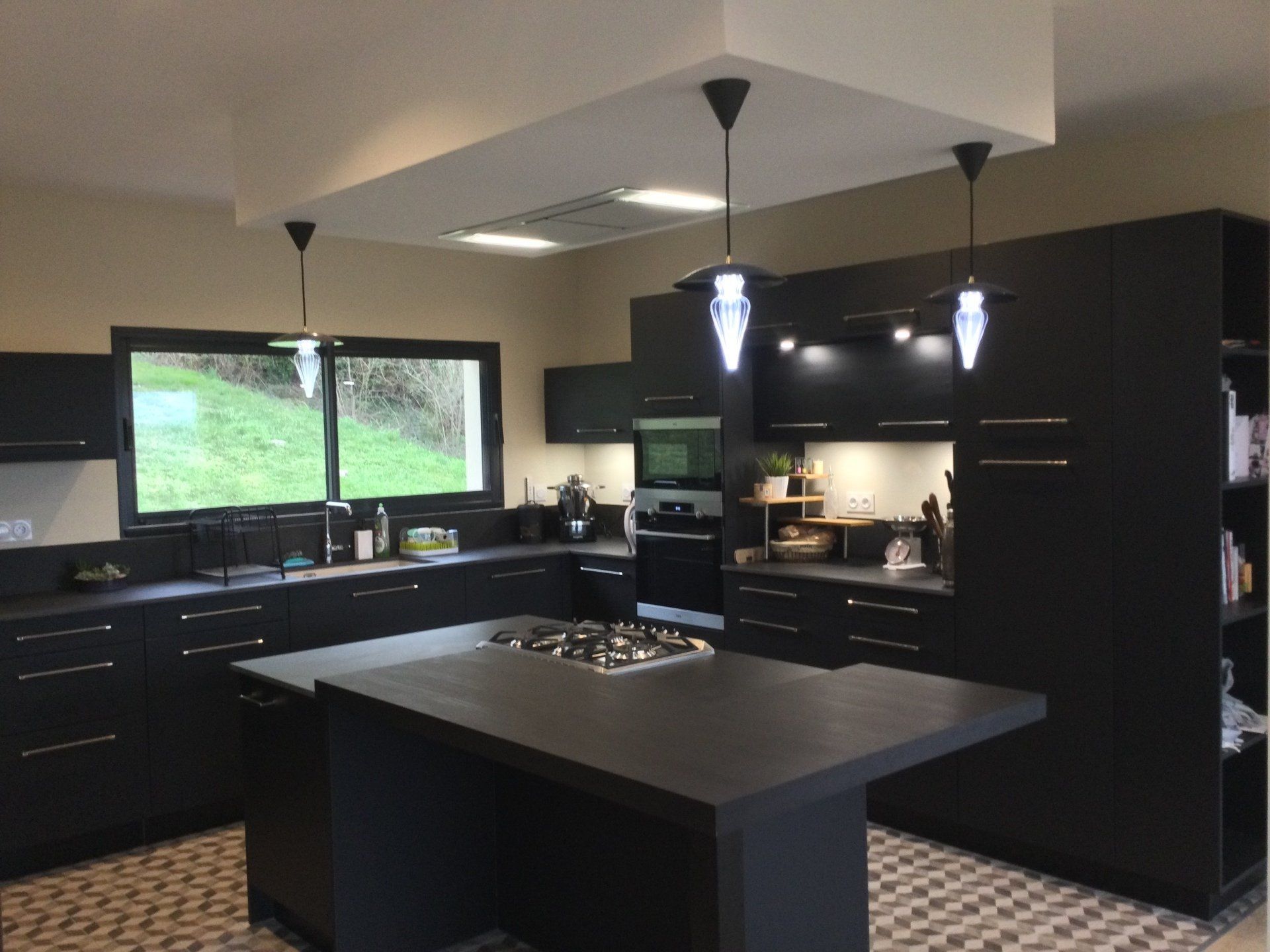 Cuisine moderne noire avec des luminaires 